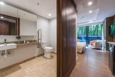 a bathroom with a toilet and a sink and a bed at El Tesoro Medellín Hab314 by Letoh in Medellín