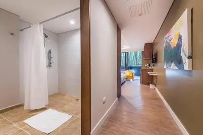 a hallway of a bathroom with a shower and a sink at El Tesoro Medellín Hab315 by Letoh in Medellín