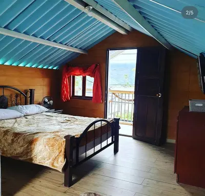 a bedroom with a bed and a blue ceiling at HOSTAL MACONDO in Manizales