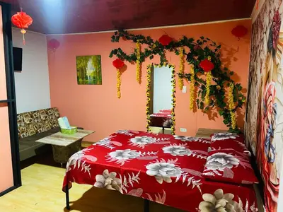 a bedroom with a red bed with flowers on it at EL EDEN HABITACIONES in Manizales