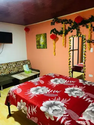 a bedroom with a red bed with flowers on it at EL EDEN HABITACIONES in Manizales