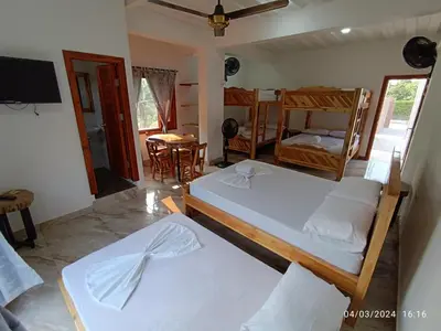 a bedroom with two beds and a dining room at La ceiba casa campestre in Sonsón