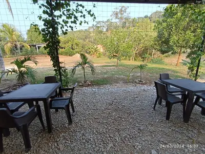 a group of tables and chairs in a garden at La ceiba casa campestre in Sonsón