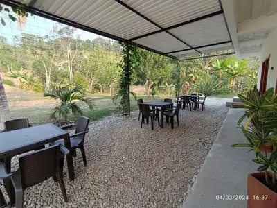 a group of tables and chairs in a patio at La ceiba casa campestre in Sonsón