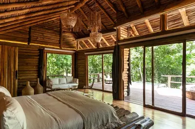 a bedroom with a large bed in a room with windows at Hotel Boutique Maitta en Doradal Antioquia in Doradal