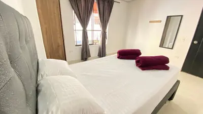 a white bed with two red pillows on it at Apartamento Balcón 201 in San Luis