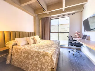a bedroom with a bed and a desk and a window at B 48 Living by B Rent in Medellín