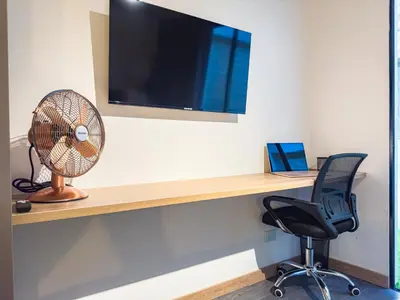 an office with a desk with a fan and a chair at B 48 Living by B Rent in Medellín