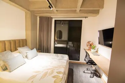 a bedroom with a bed and a desk with a computer at B 48 Living by B Rent in Medellín