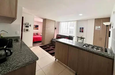 a kitchen with a counter top and a living room at Confortable apartaestudio in Manizales