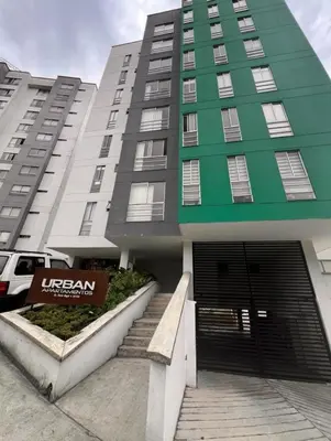 a green and white building with a garage at Confortable apartaestudio in Manizales