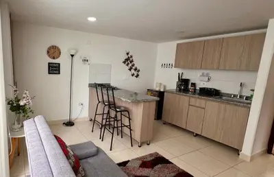 a kitchen with a couch and a counter in a room at Confortable apartaestudio in Manizales