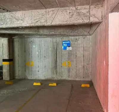a parking garage with a blue parking sign in it at Confortable apartaestudio in Manizales