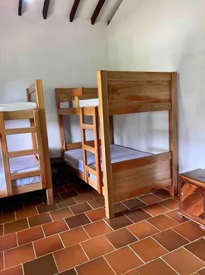 two bunk beds in a room with a brick floor at Finca Sierra Luz in Jericó
