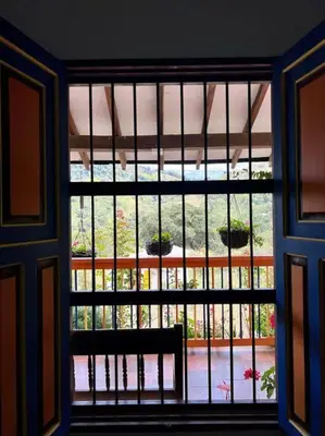 a window with a view of a garden seen through it at Finca Sierra Luz in Jericó