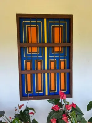 a stained glass window on a wall with a plant at Finca Sierra Luz in Jericó