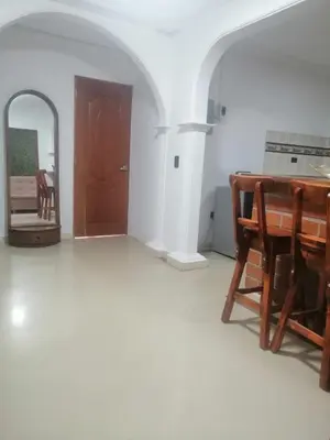 a living room with a wooden table and a mirror at Apartamento Rionegro cerca a Aeropuerto in Rionegro