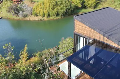 an aerial view of a house next to a river at Cabaña con jacuzzi y acceso al embalse - Portum II in El Peñol