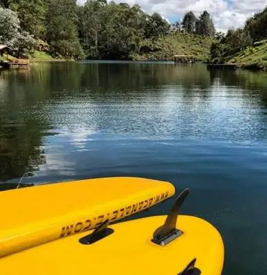 a yellow kayak sitting on top of a body of water at Cabaña con jacuzzi y acceso al embalse - Portum II in El Peñol