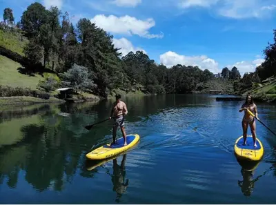a man and a woman on paddle boards on a river at Cabaña con jacuzzi y acceso al embalse - Portum II in El Peñol
