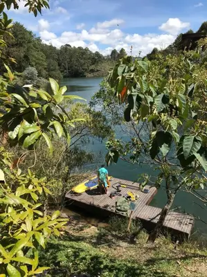 a person sitting on a dock in the water at Cabaña con jacuzzi y acceso al embalse - Portum I in El Peñol