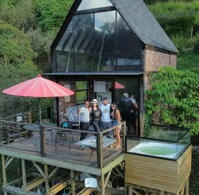 a group of people standing on the deck of a house at Cabaña con jacuzzi y acceso al embalse - Portum I in El Peñol