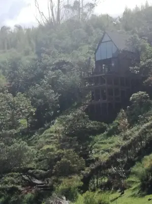 a house on the side of a hill with trees at Cabaña con jacuzzi y acceso al embalse - Portum I in El Peñol