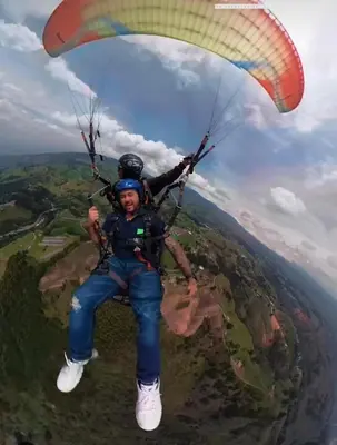 a man flying through the air with a parachute at perla 3 dormitorios in Bello