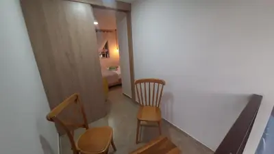 a hallway with two chairs and a room with a bed at AZAHARES HOTEL Y CAFÉ in Manizales