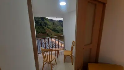 a room with a balcony with a table and chairs at AZAHARES HOTEL Y CAFÉ in Manizales