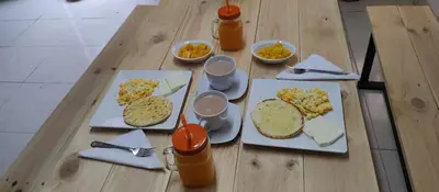 a wooden table topped with plates of food and drinks at Chalet Lupe-Eje cafetero in Palestina