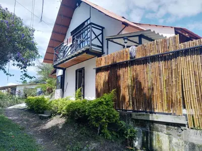 a house with a wooden fence in front of it at Chalet Lupe-Eje cafetero in Palestina