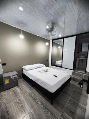 a bedroom with a large bed and a mirror at HOSPEDAJE EL ENSUEÑO in Doradal