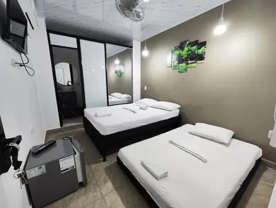 a room with two beds and a mirror at HOSPEDAJE EL ENSUEÑO in Doradal