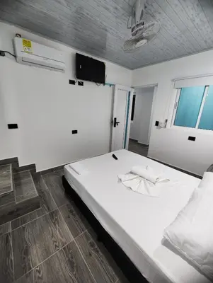 a large white bed in a room with a window at HOSPEDAJE EL ENSUEÑO in Doradal