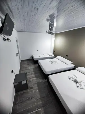 a room with two beds and a tv on the ceiling at HOSPEDAJE EL ENSUEÑO in Doradal