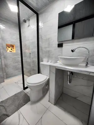 a bathroom with a toilet and a sink and a shower at HOSPEDAJE EL ENSUEÑO in Doradal