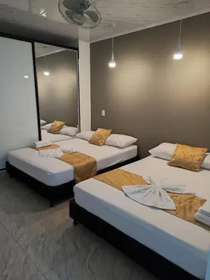 a room with three beds in a room at HOSPEDAJE EL ENSUEÑO in Doradal