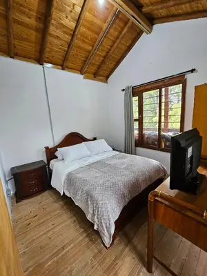 a bedroom with a bed and a tv in it at Mirador del Lago, Rural House with ideal location in Marinilla