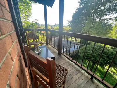 a balcony with a bench and a view of trees at Mirador del Lago, Rural House with ideal location in Marinilla