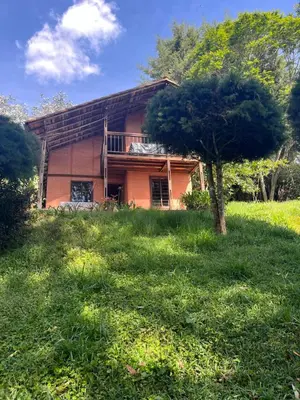 a house with a tree in front of it at Mirador del Lago, Rural House with ideal location in Marinilla
