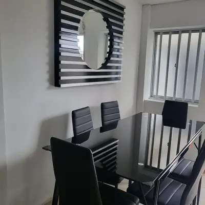 a dining room with a table and chairs and a mirror at LA CASA DEL CABLE - Hermoso Apartamento - in Manizales