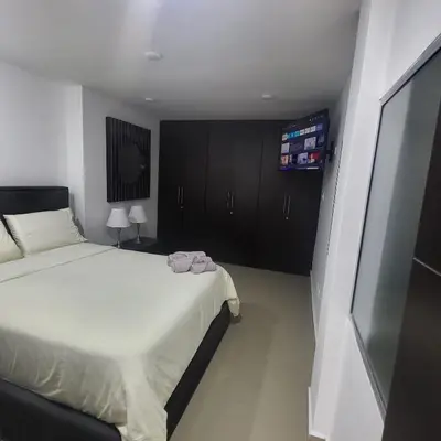 a bedroom with a bed and a flat screen tv at LA CASA DEL CABLE - Hermoso Apartamento - in Manizales