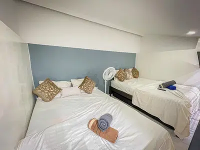 a room with two beds with hats on them at Loft Urbano la 70 Laurles estadio in Medellín