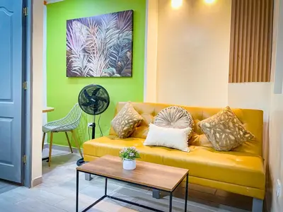 a living room with a yellow couch and a table at Loft Urbano la 70 Laurles estadio in Medellín