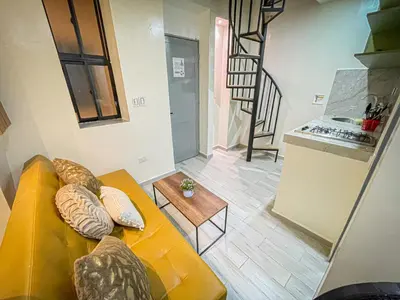 a living room with a yellow couch and a table at Loft Urbano la 70 Laurles estadio in Medellín