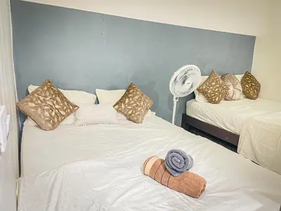a bedroom with two beds with pillows and a fan at Loft Urbano la 70 Laurles estadio in Medellín
