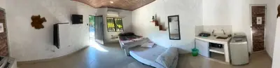 a room with a kitchen with a table in it at Hospedaje Luz d' Luna in Puerto Triunfo