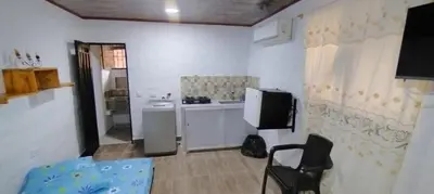 a kitchen with a refrigerator and a chair in a room at Hospedaje Luz d' Luna in Puerto Triunfo