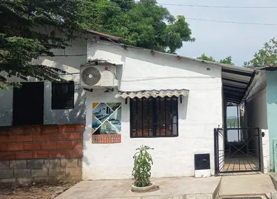 a white house with a fan on the side of it at Hospedaje Luz d' Luna in Puerto Triunfo